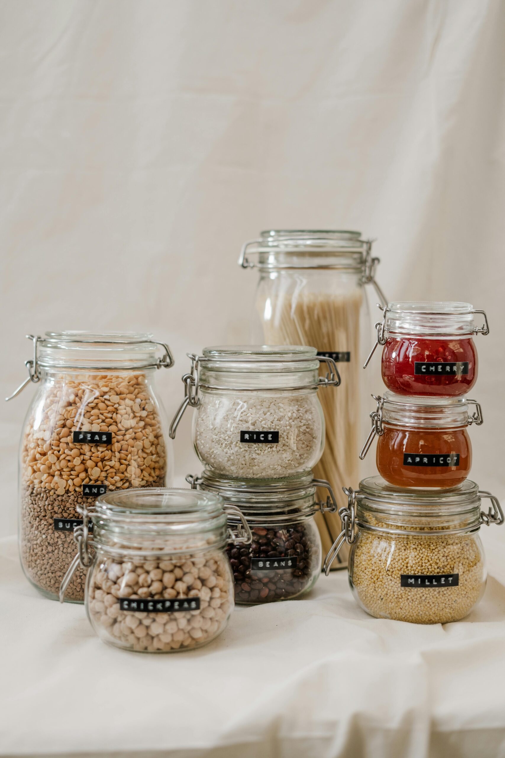 Stylish glass jars for zero waste kitchen storage, featuring grains and dried goods.